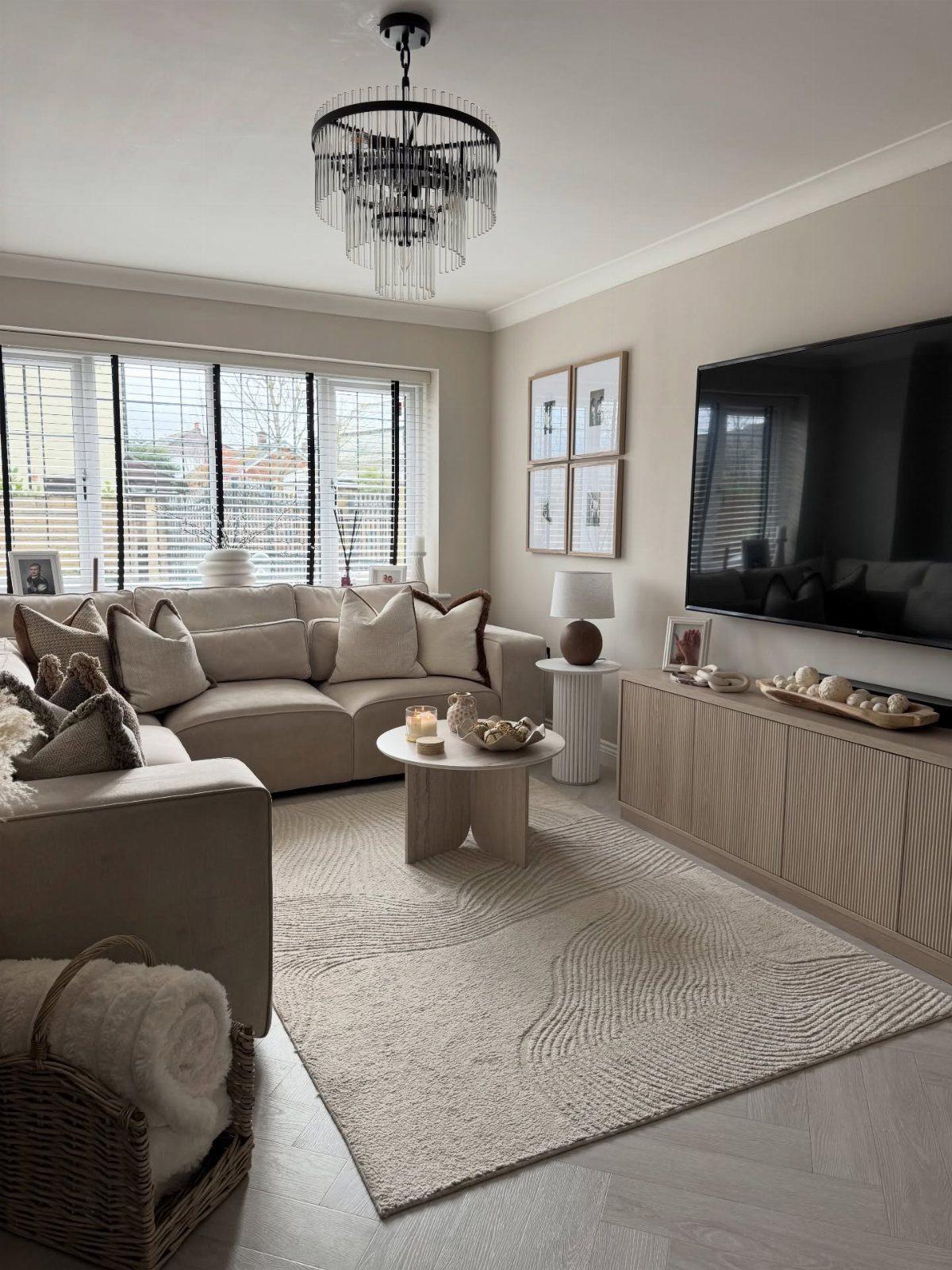 Beige sectional sofa with grey accent pillows in a neutral modern living room.