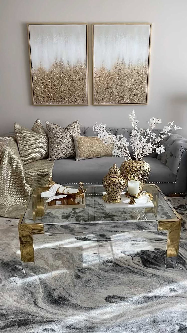 Grey tufted sofa and glass coffee table in a beige and grey living room