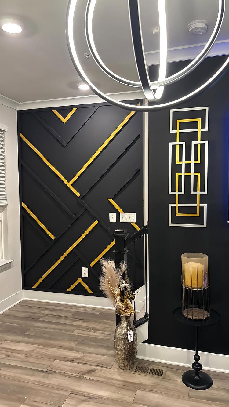 Black accent wall with gold and black geometric slats in a modern room.
