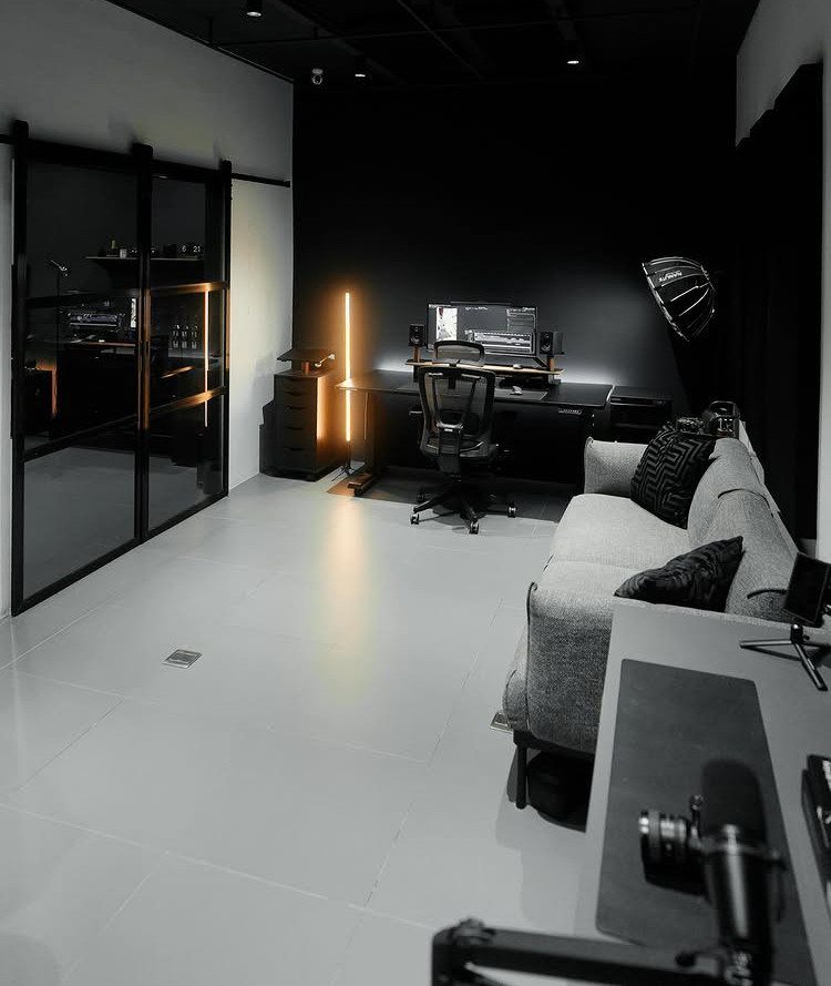 Modern room with a black accent wall, office desk, and grey sofa.