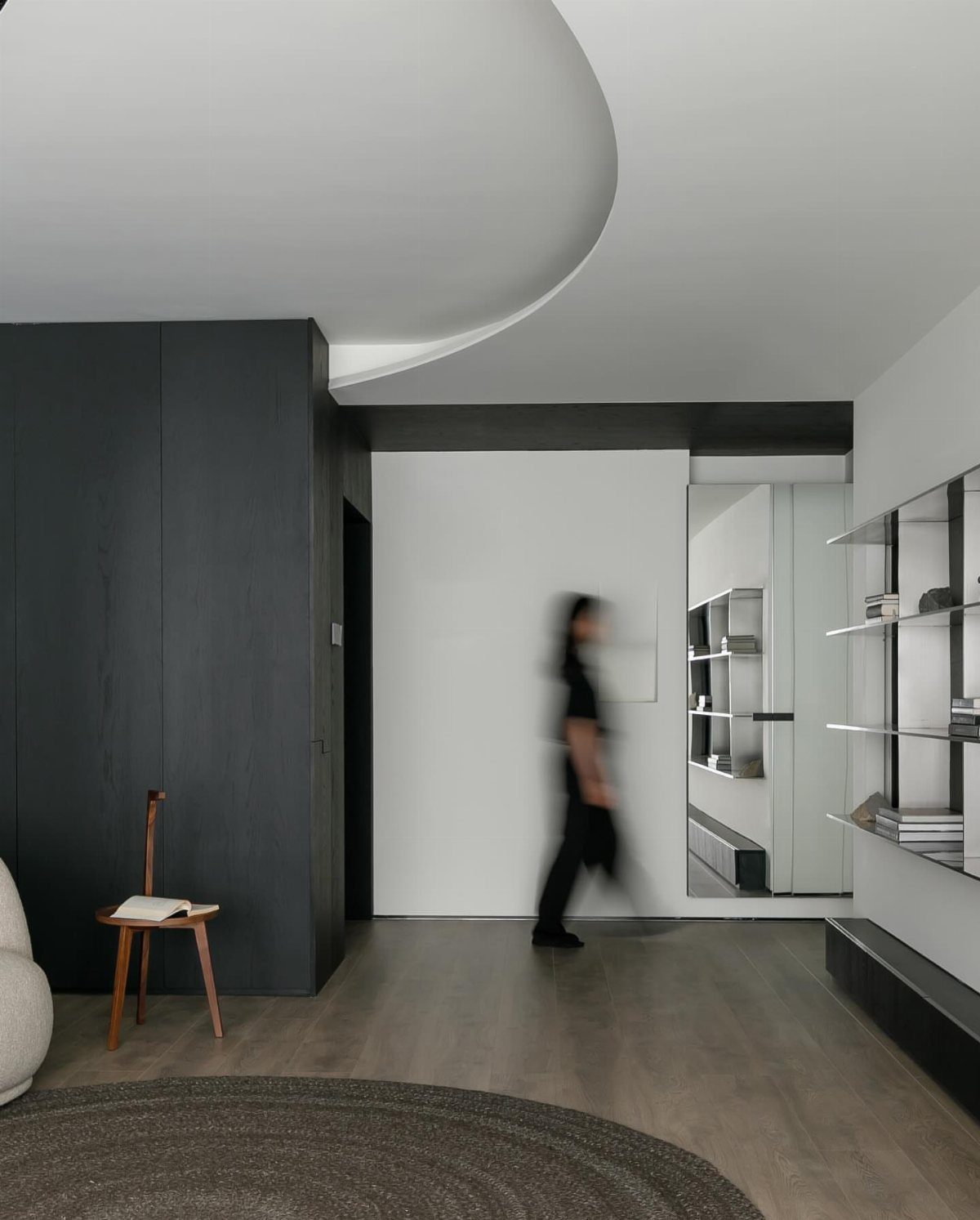 Dark charcoal accent wall in a modern living room with white walls and wood floors.