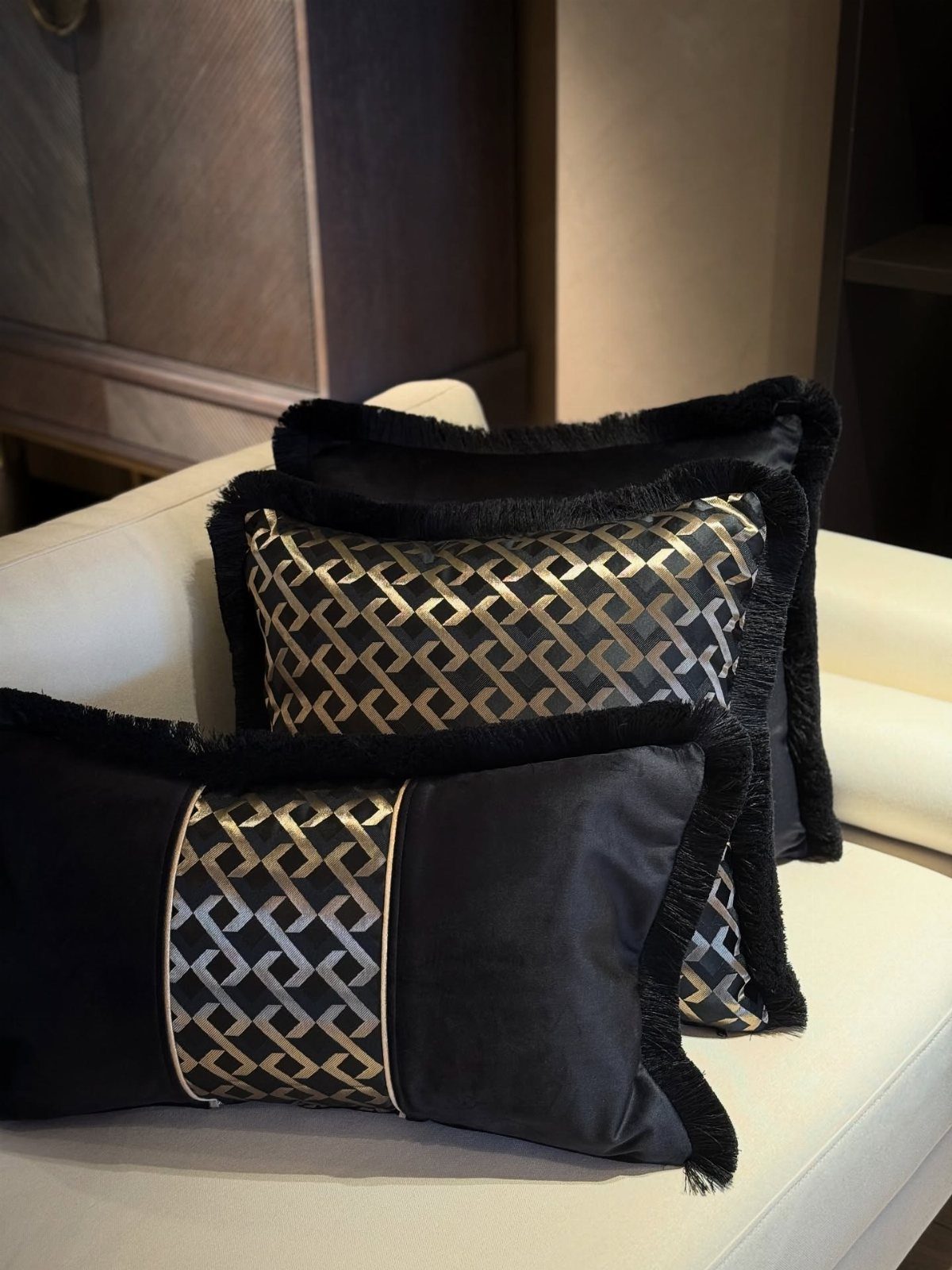 17 Black and Gold Living Room Ideas for Luxe Style 11 Black and gold geometric decorative pillows with fringe on a white sofa.