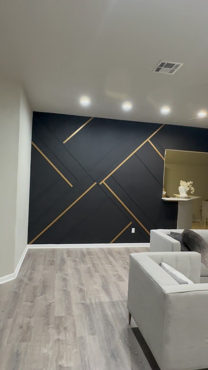 17 Black and Gold Living Room Ideas for Luxe Style 14 Black accent wall with gold geometric strips in a modern living room