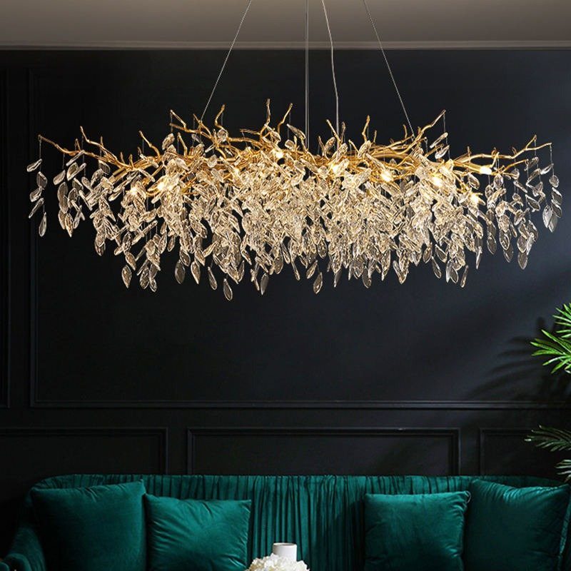 17 Black and Gold Living Room Ideas for Luxe Style 6 Golden chandelier with crystal leaves hanging above a green velvet sofa against black walls.