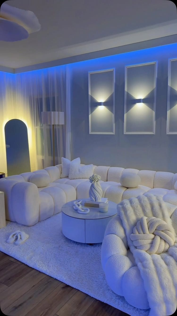 Modern white living room with blue LED ceiling lighting and modular white furniture.