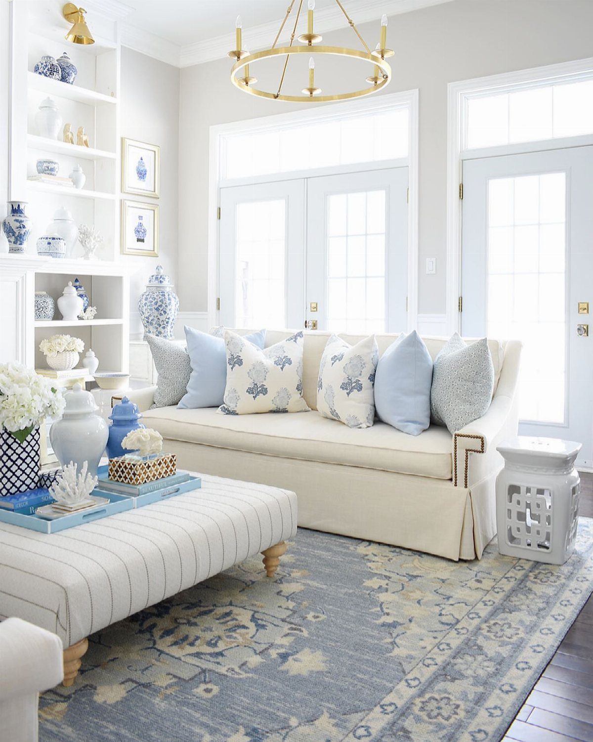 Blue and white patterned area rug in a bright living room with beige sofa.