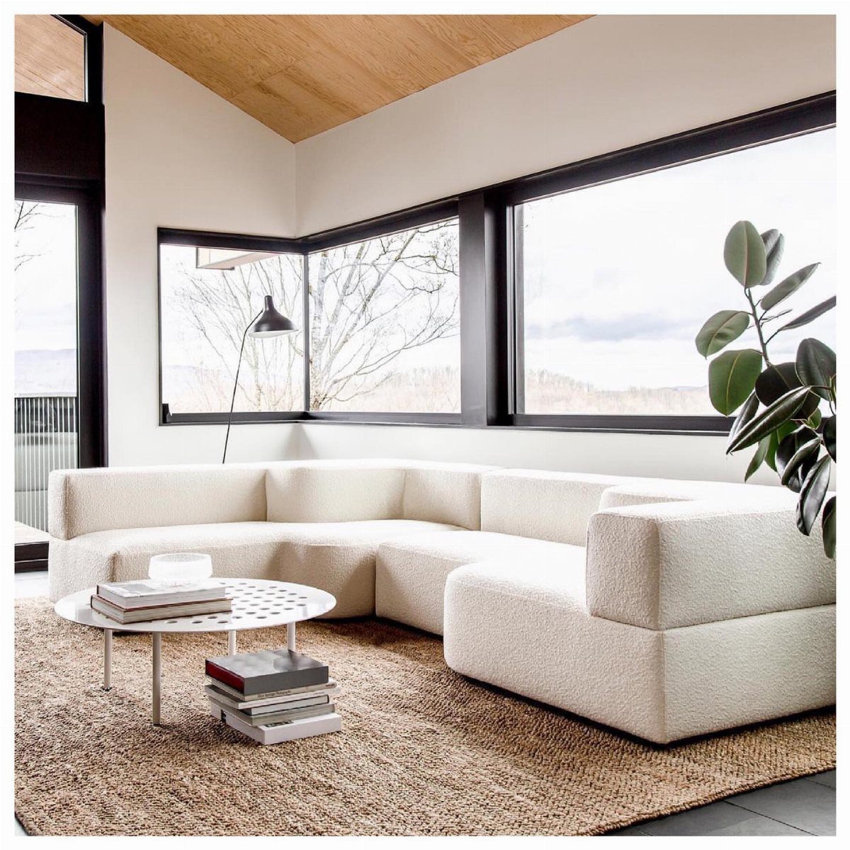 Brown jute living room rug under a white modular sectional sofa and coffee table.