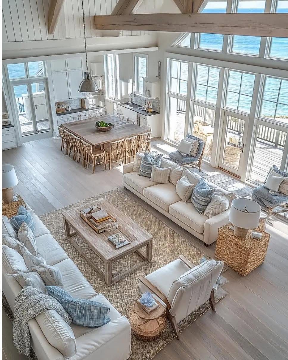 Coastal living room with white sofas and a neutral woven rug overlooking the ocean.