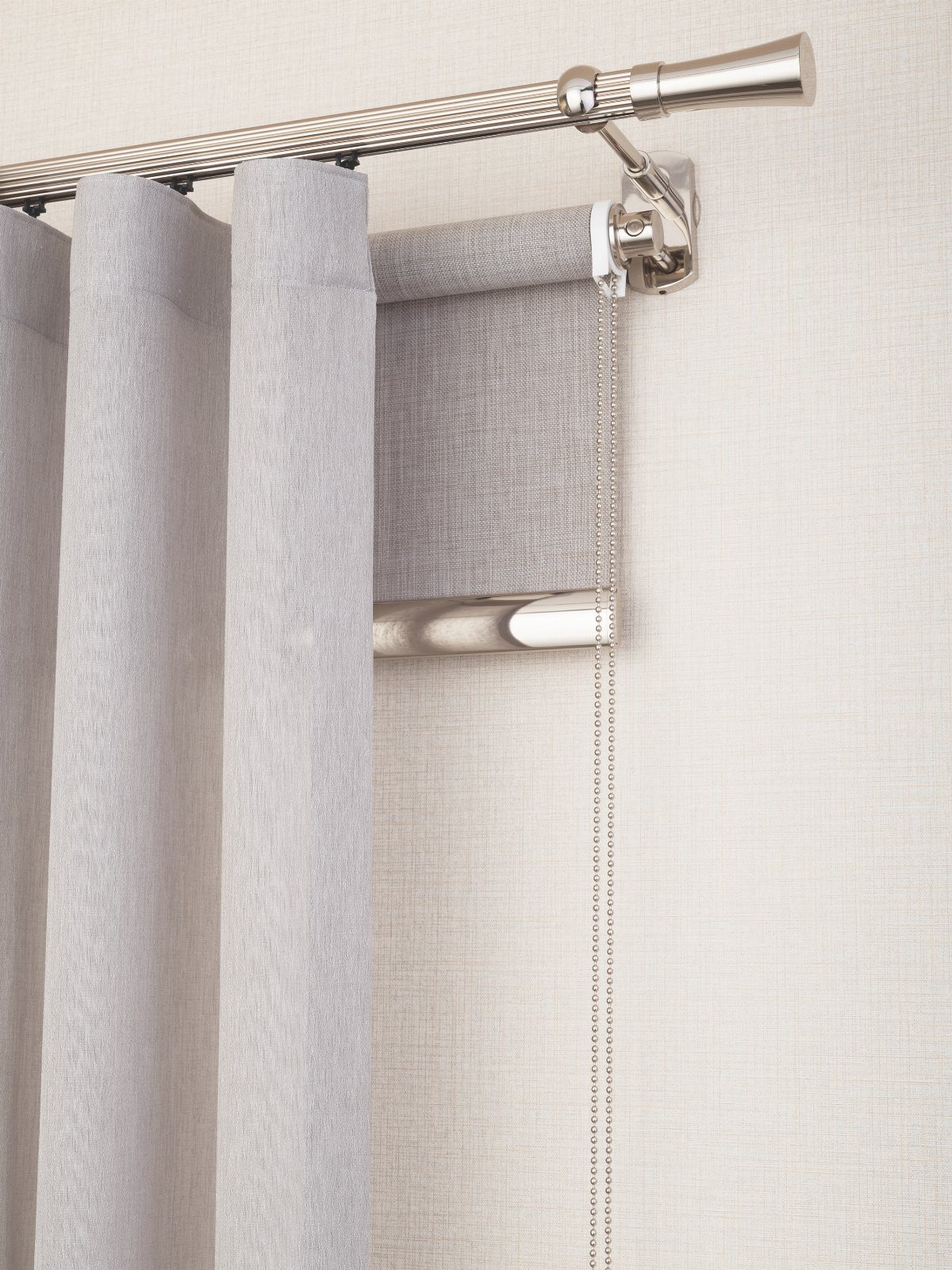 Light grey curtains and a roller blind hanging from a silver metal rod.