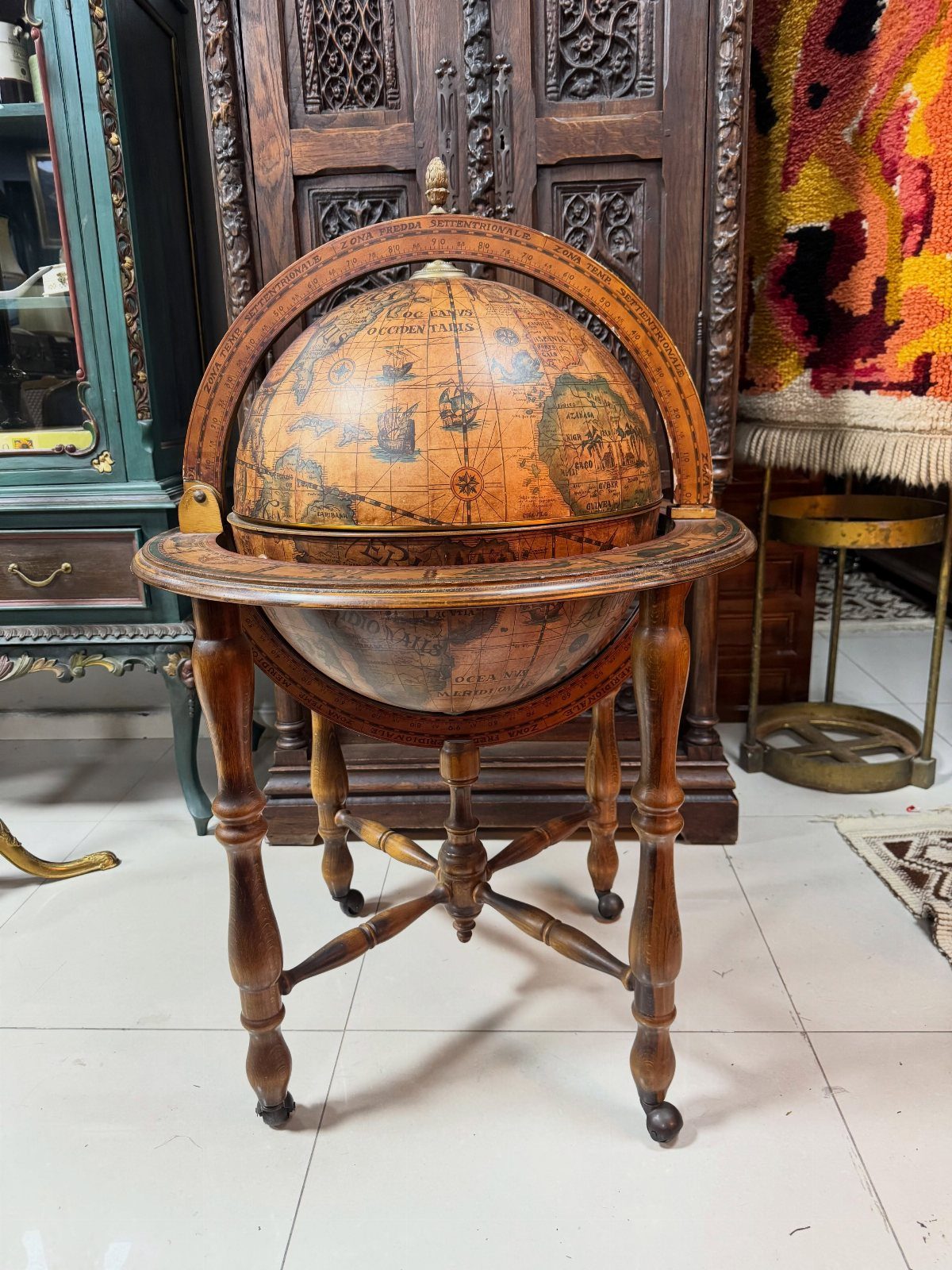 Antique world globe on a wooden stand in a vintage room setting.