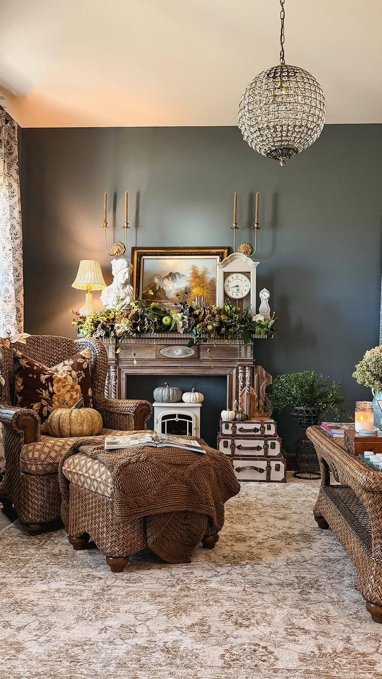 Wicker armchair and ottoman in a living room with deep blue walls and fireplace.