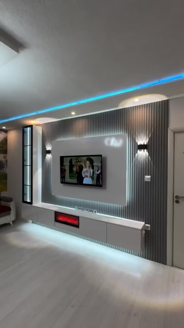 Modern living room wall with grey ribbed paneling, television, and blue LED lighting.