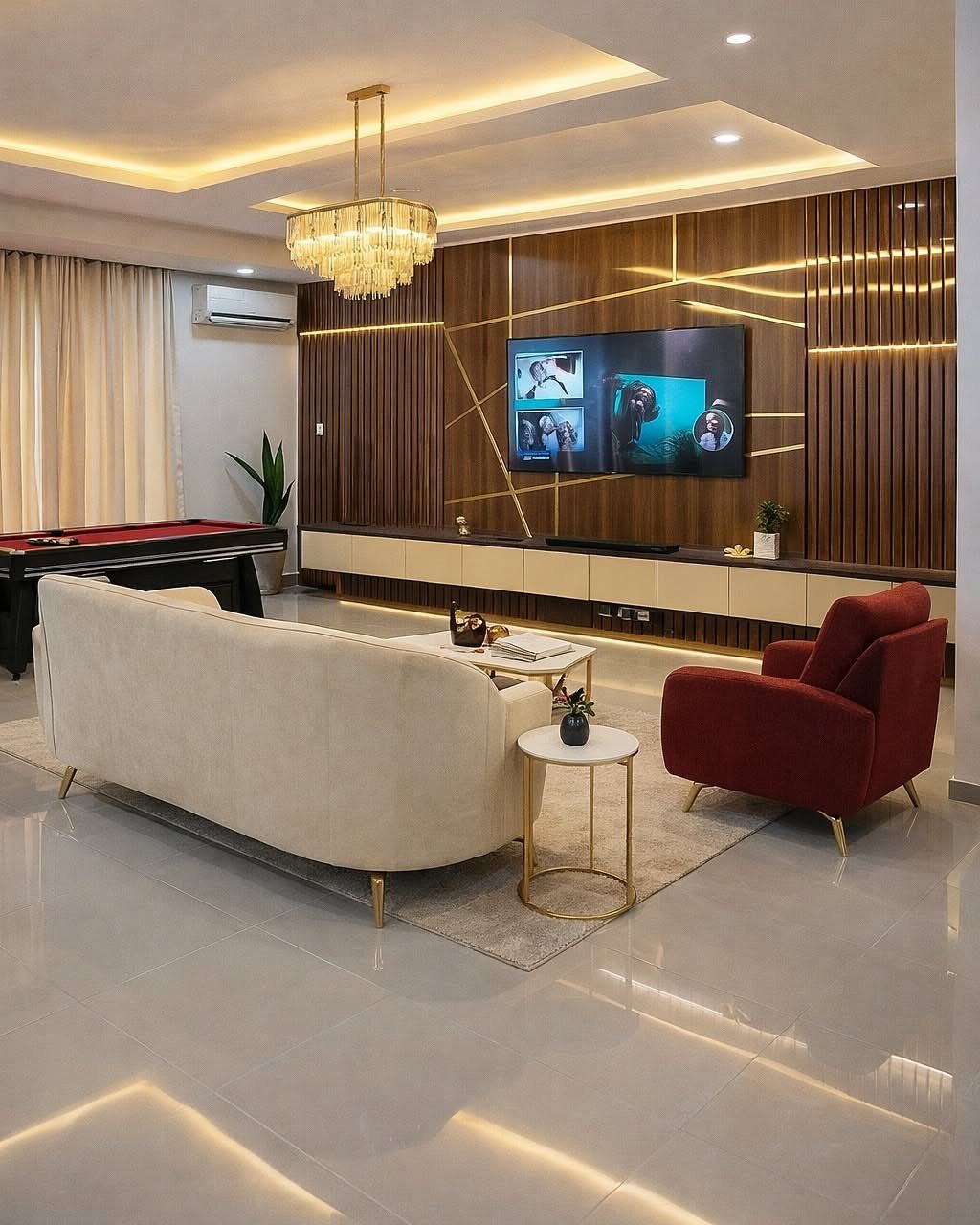 Modern living room with cream sofa and red armchair arranged around a television.