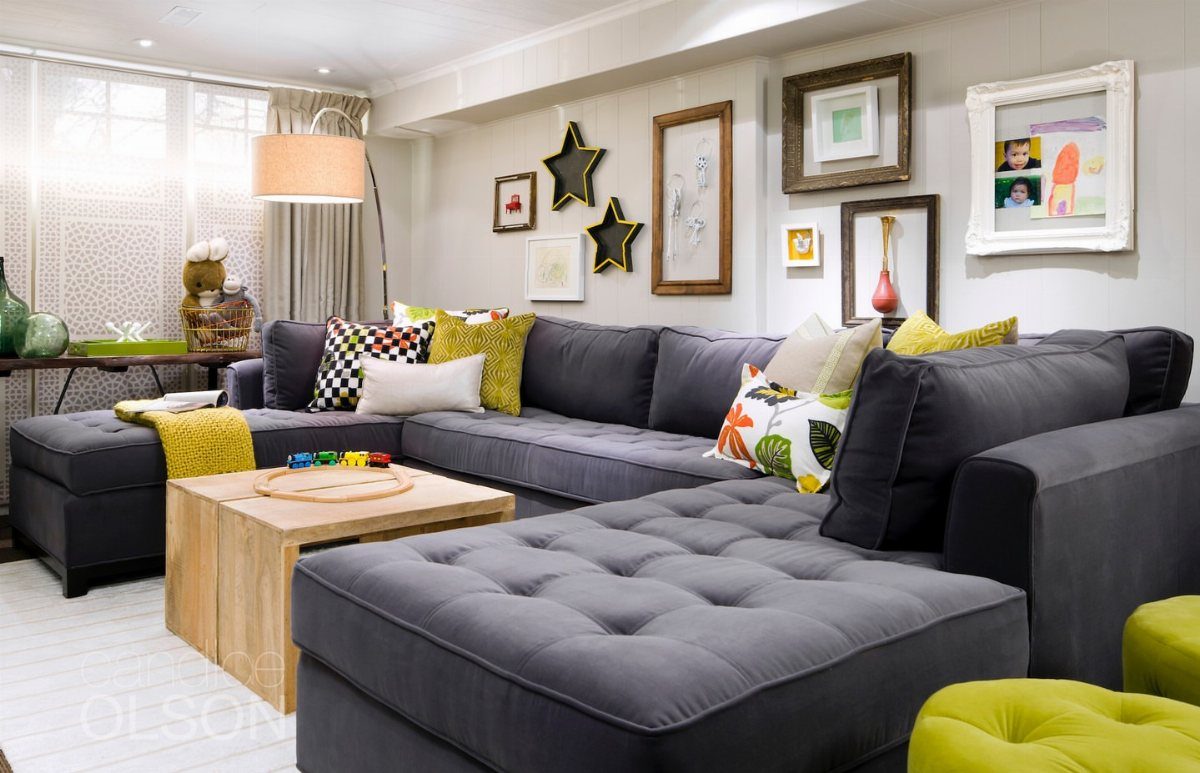 Large grey sectional sofa with colorful pillows and a light wood coffee table.