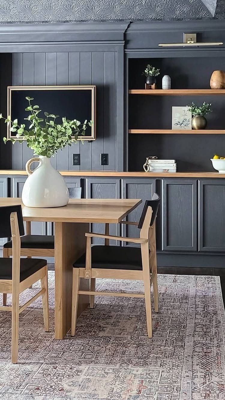 Built-in wooden shelves against a dark grey paneled wall in a dining room.