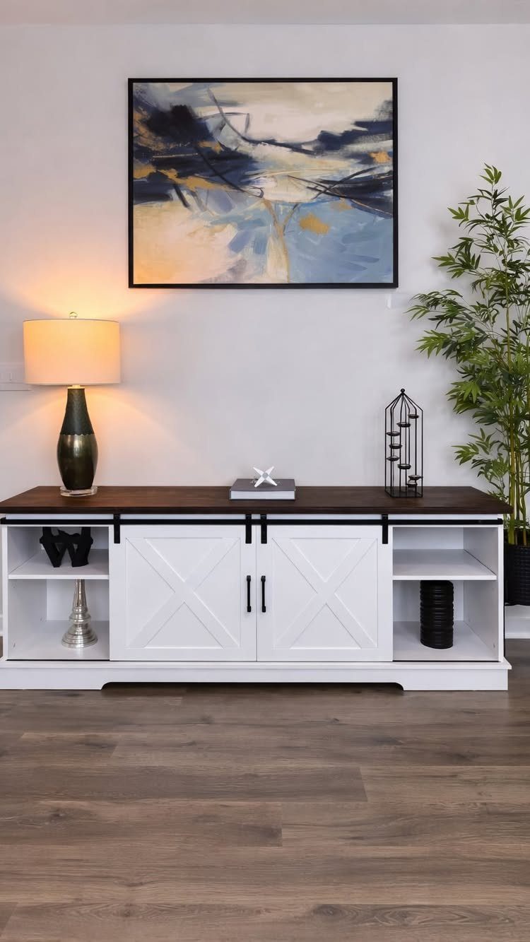 White farmhouse sideboard with dark wood top and abstract art on white wall