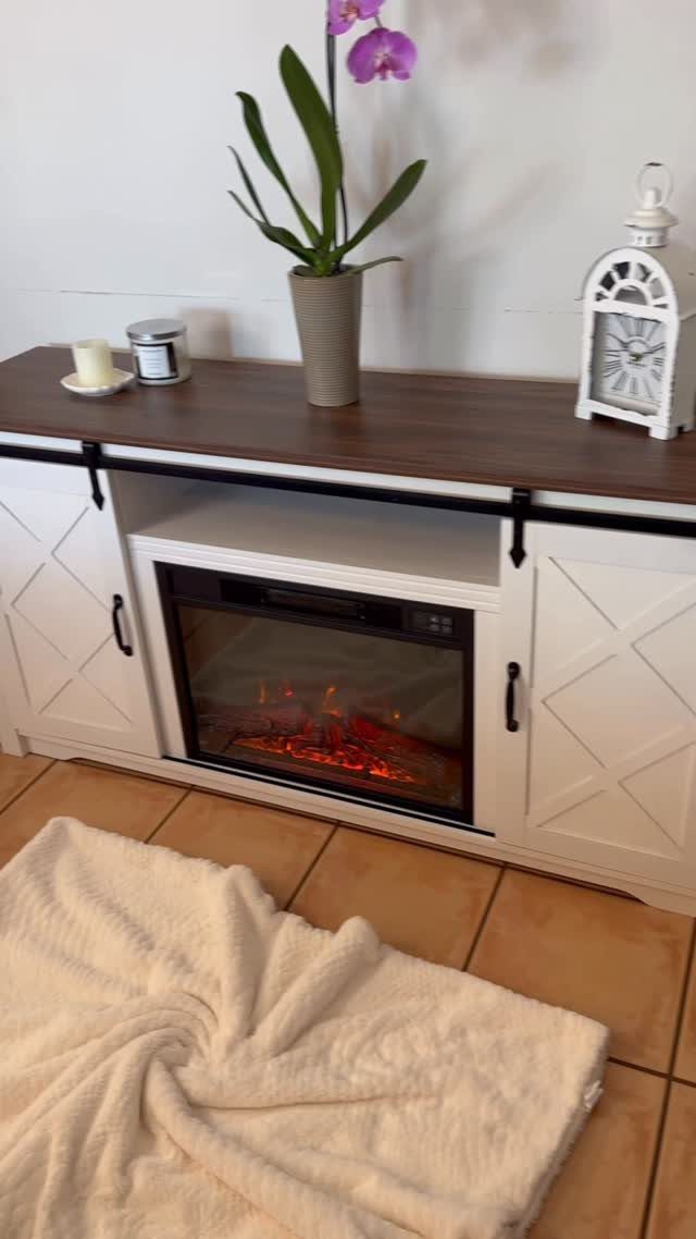White farmhouse TV stand with sliding barn doors and an integrated electric fireplace.