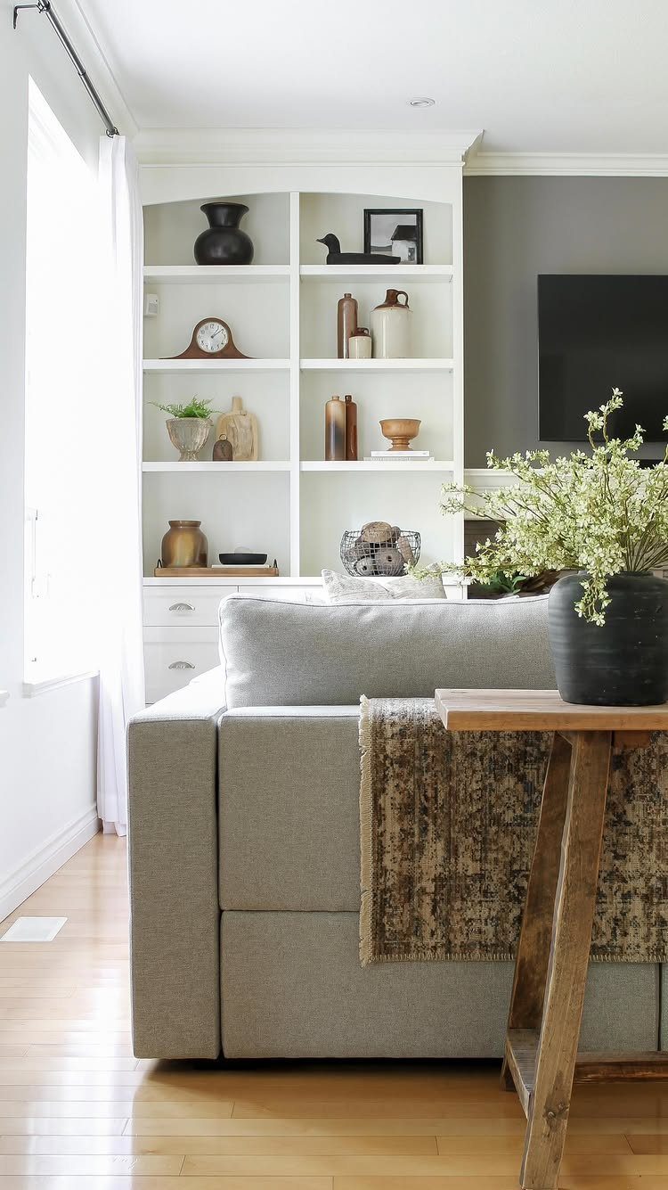 Gray fabric sofa with a textured brown throw blanket in a bright living room.
