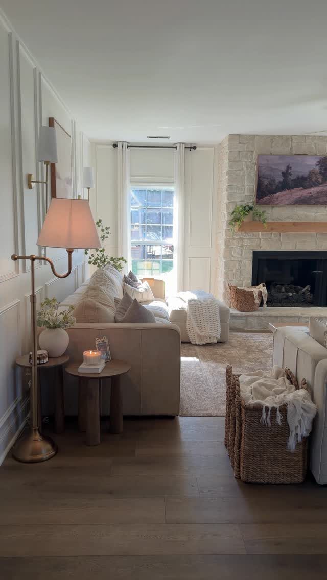 Warm taupe living room with a stone fireplace, cream sofa, and natural wood floors.