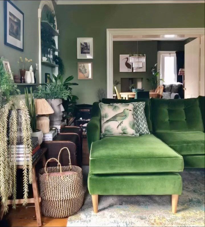 9 Green Couch Living Room Ideas for a Fresh Look 1 Green velvet sectional sofa with a bird pillow in a room with green walls.