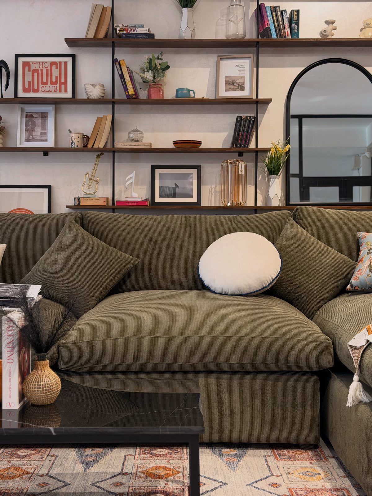 9 Green Couch Living Room Ideas for a Fresh Look 4 Sage green corduroy sectional sofa with pillows in a living room with shelving.