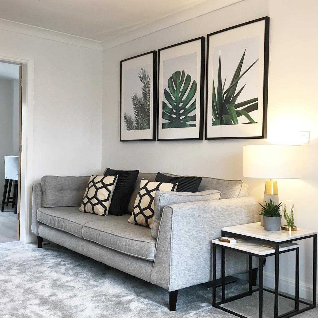 15 Grey Sofa Living Room Ideas with Real Style 7 Grey fabric sofa with geometric pillows and botanical art on white wall.