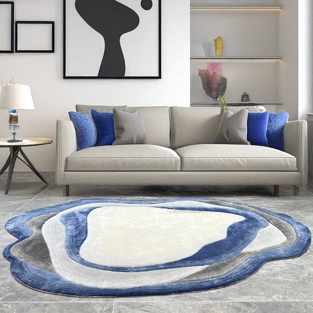 Blue and white abstract area rug in a modern living room with beige sofa.