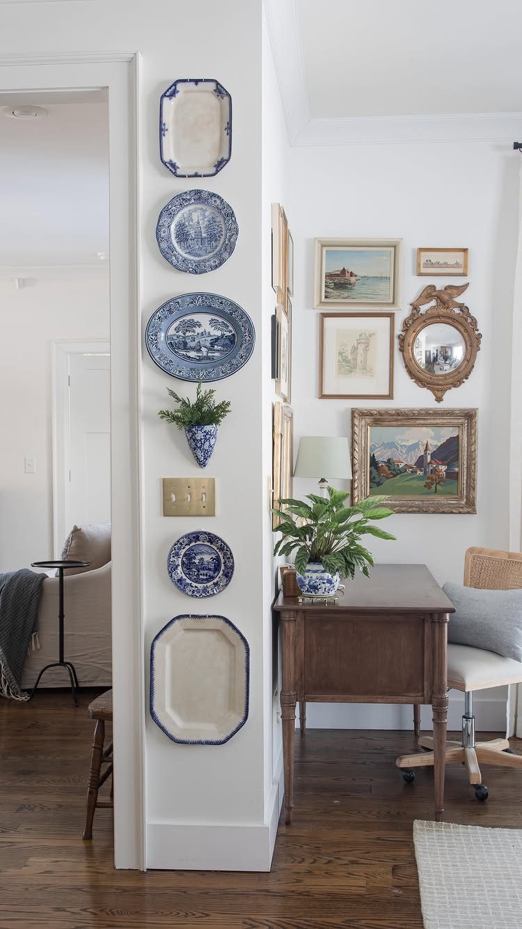 Blue and white ceramic plates arranged vertically on a white interior wall.