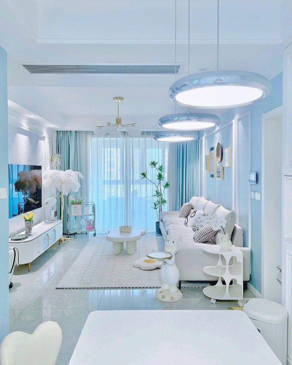 Light blue living room with matching light blue ceiling and white furniture.