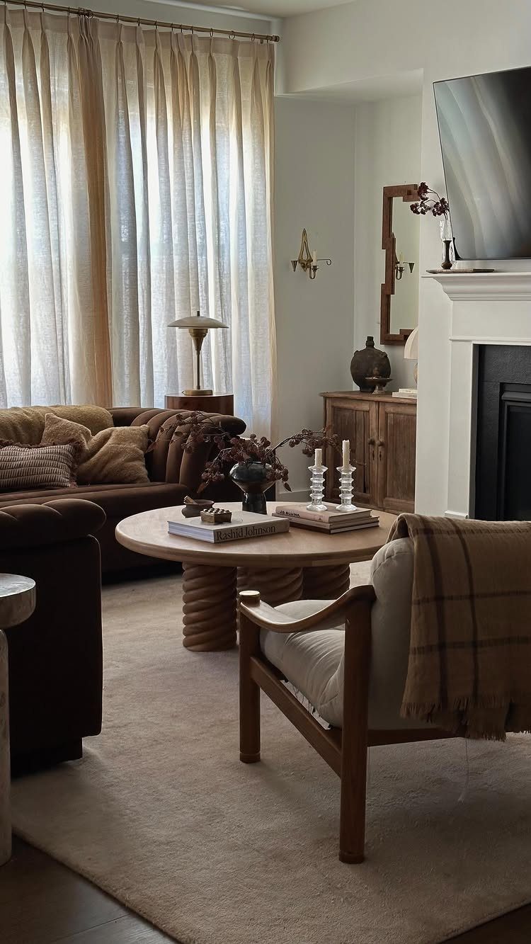 Cozy living room arrangement with a brown sofa, wooden armchair, and round coffee table.