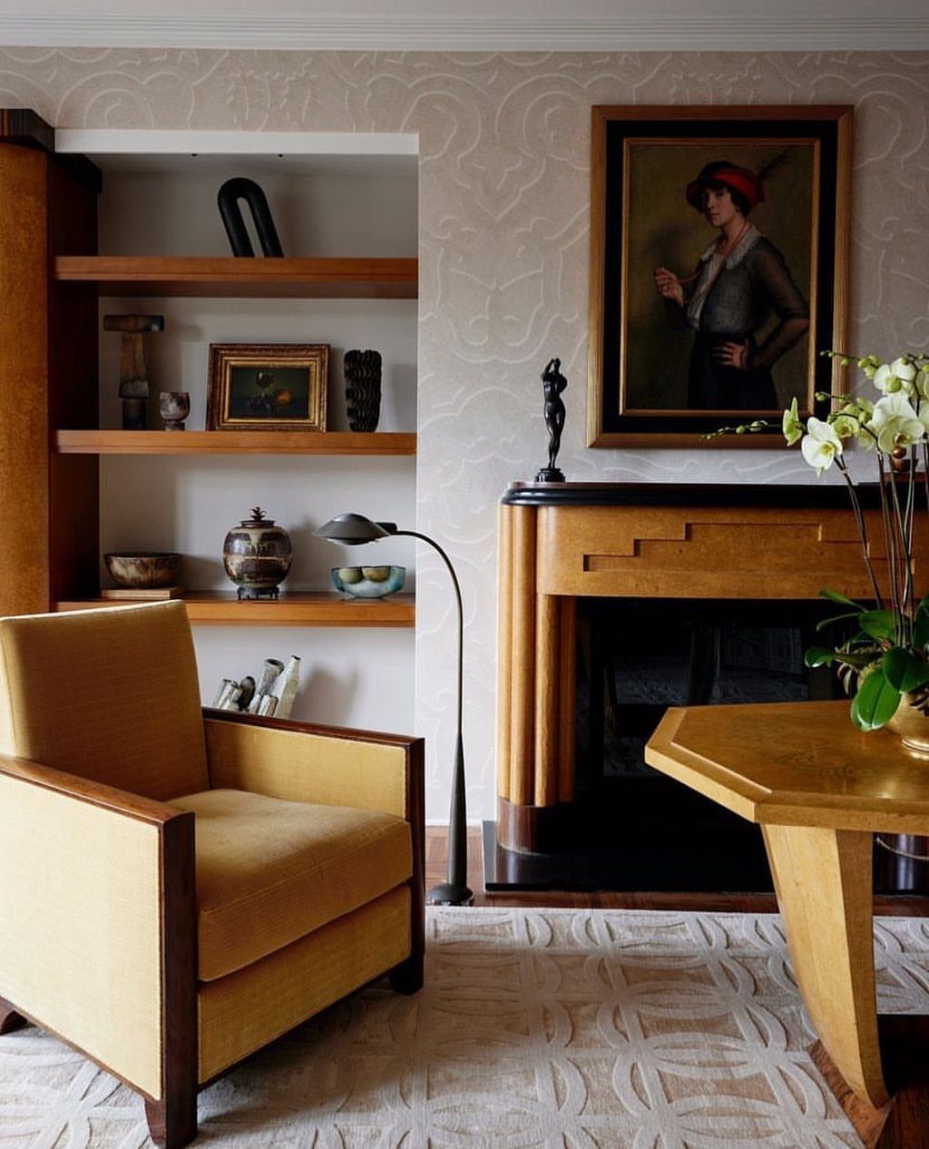 Yellow armchair and wooden table in a living room with a fireplace.