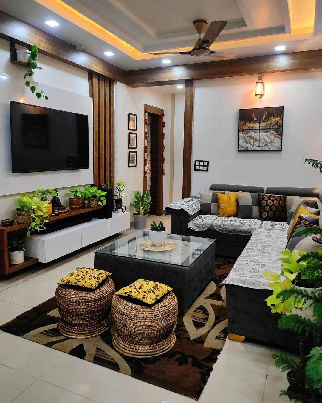 Modern living room with grey sectional sofa, glass coffee table, and woven poufs.