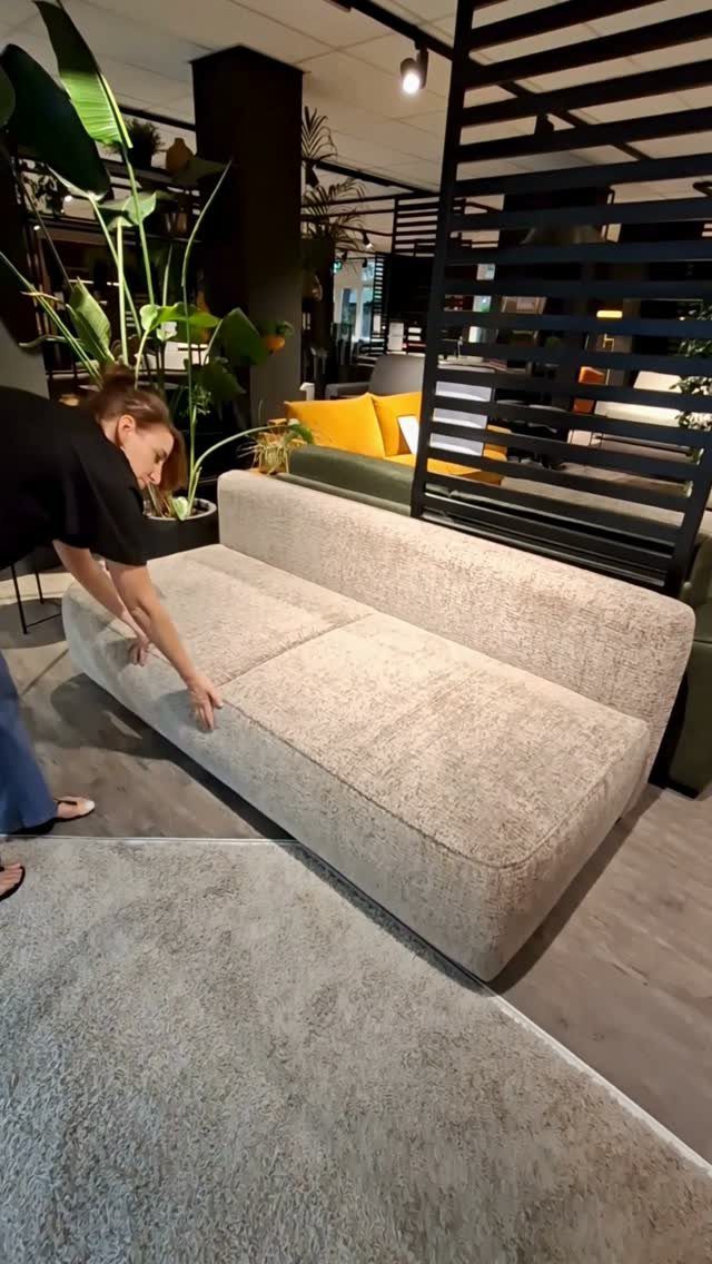 9 Living Room Couch Ideas for a Stylish Space 4 Light beige armless sofa in a modern living room showroom with black divider.