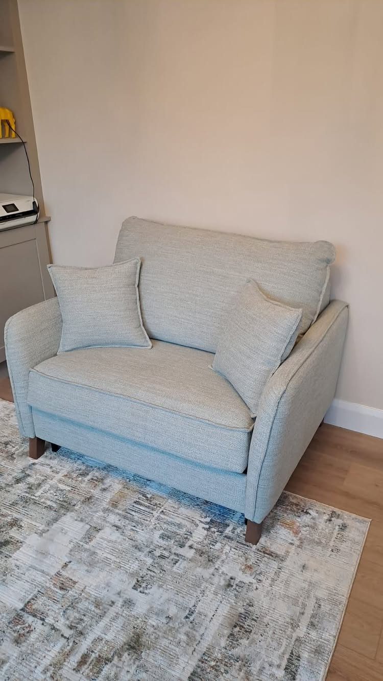 9 Living Room Couch Ideas for a Stylish Space 1 Light grey fabric loveseat with two pillows on a patterned area rug.