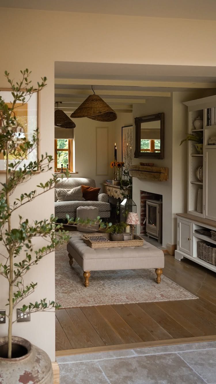 Cozy living room with woven pendant lights, beige ottoman, and a fireplace.