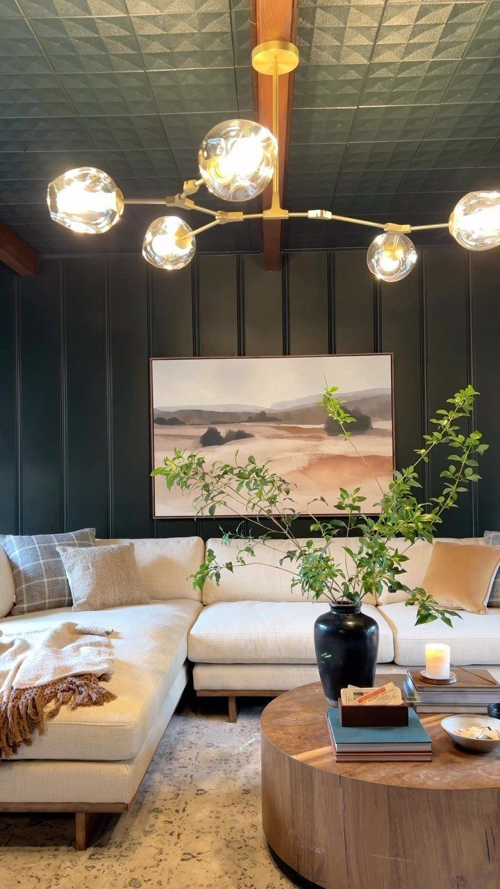 Dark green paneled living room walls and ceiling with a white sectional sofa.