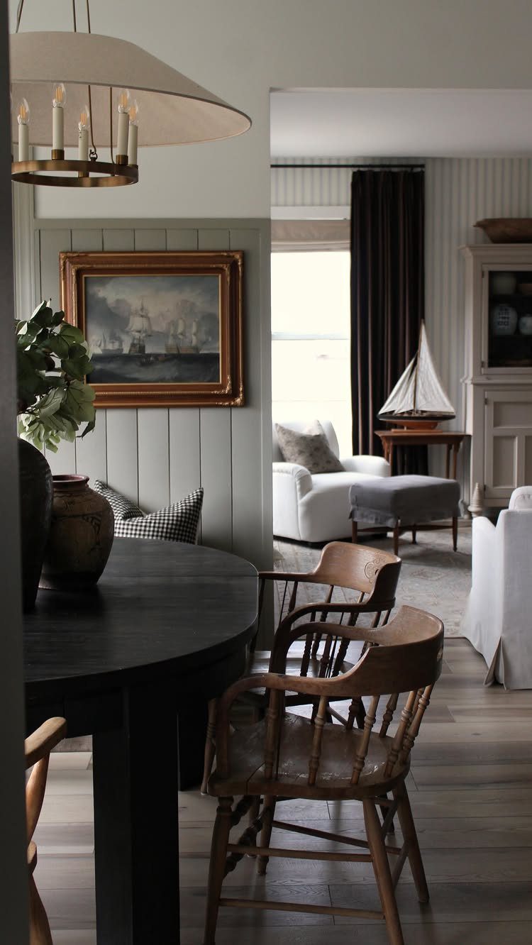 Dining and living area featuring a mix of traditional wooden chairs and modern white furniture.