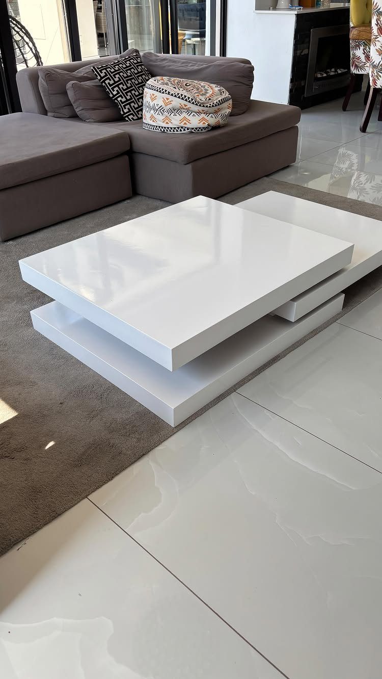 White tiered square coffee table in a modern living room with grey sectional sofa.
