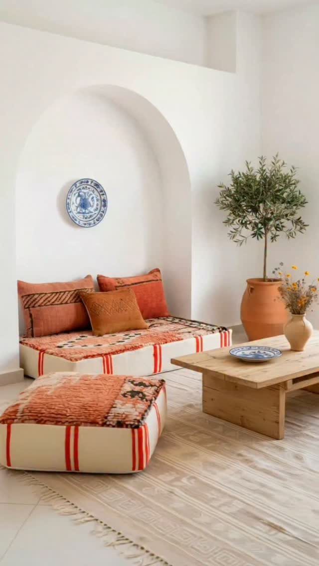Large patterned floor cushions and a low wooden table in a white room.