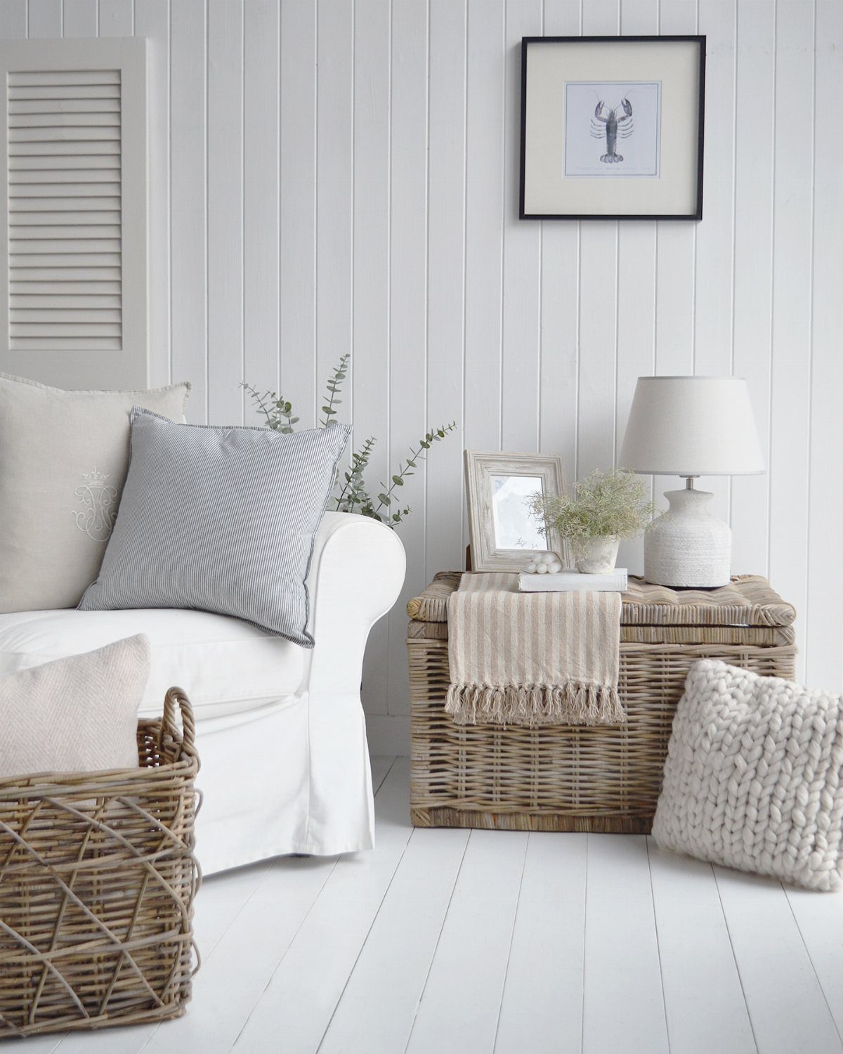 Wicker storage chest and woven basket in a bright white living room setting.