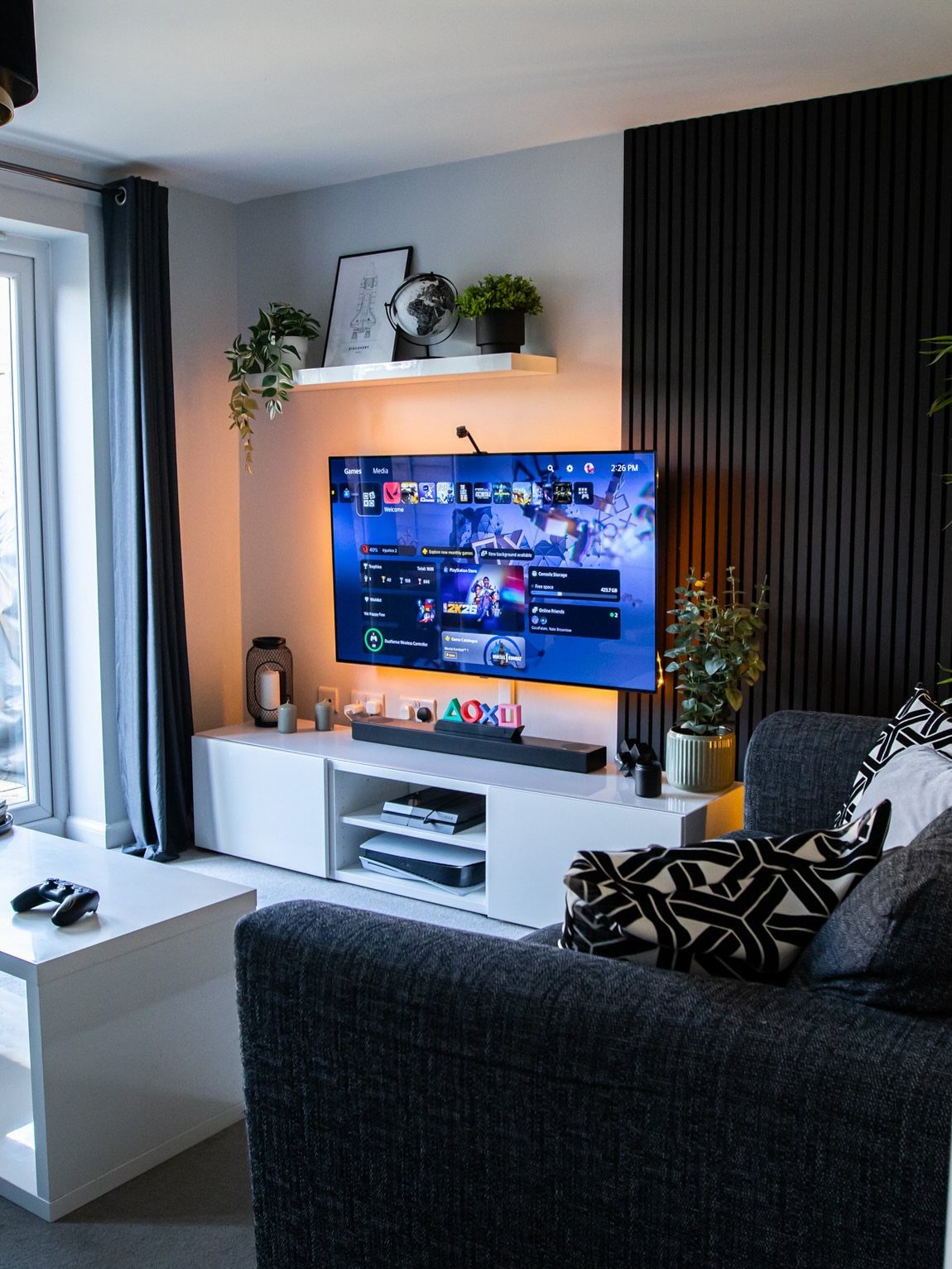 White media console with open shelving under a large television in a modern living room