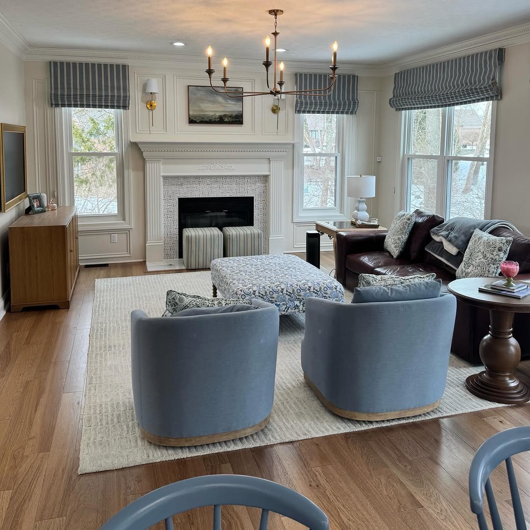 Living room with blue striped window valances, white fireplace, and blue armchairs.