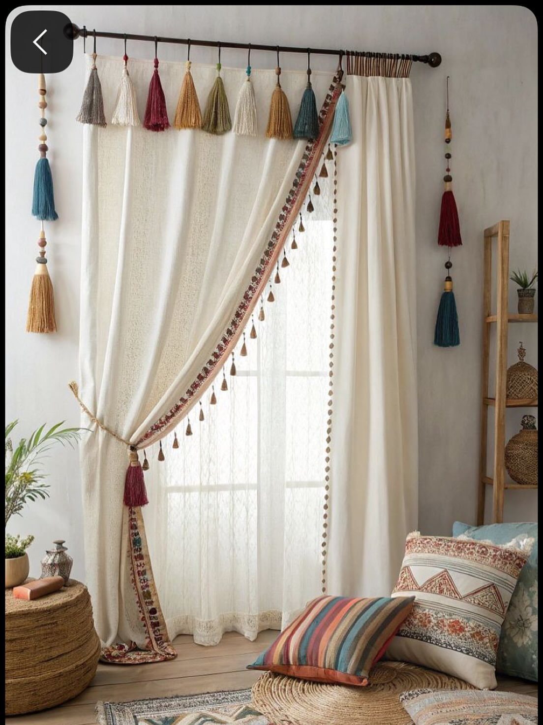 Cream curtains with a patterned valance and colorful tassels in a bohemian living room