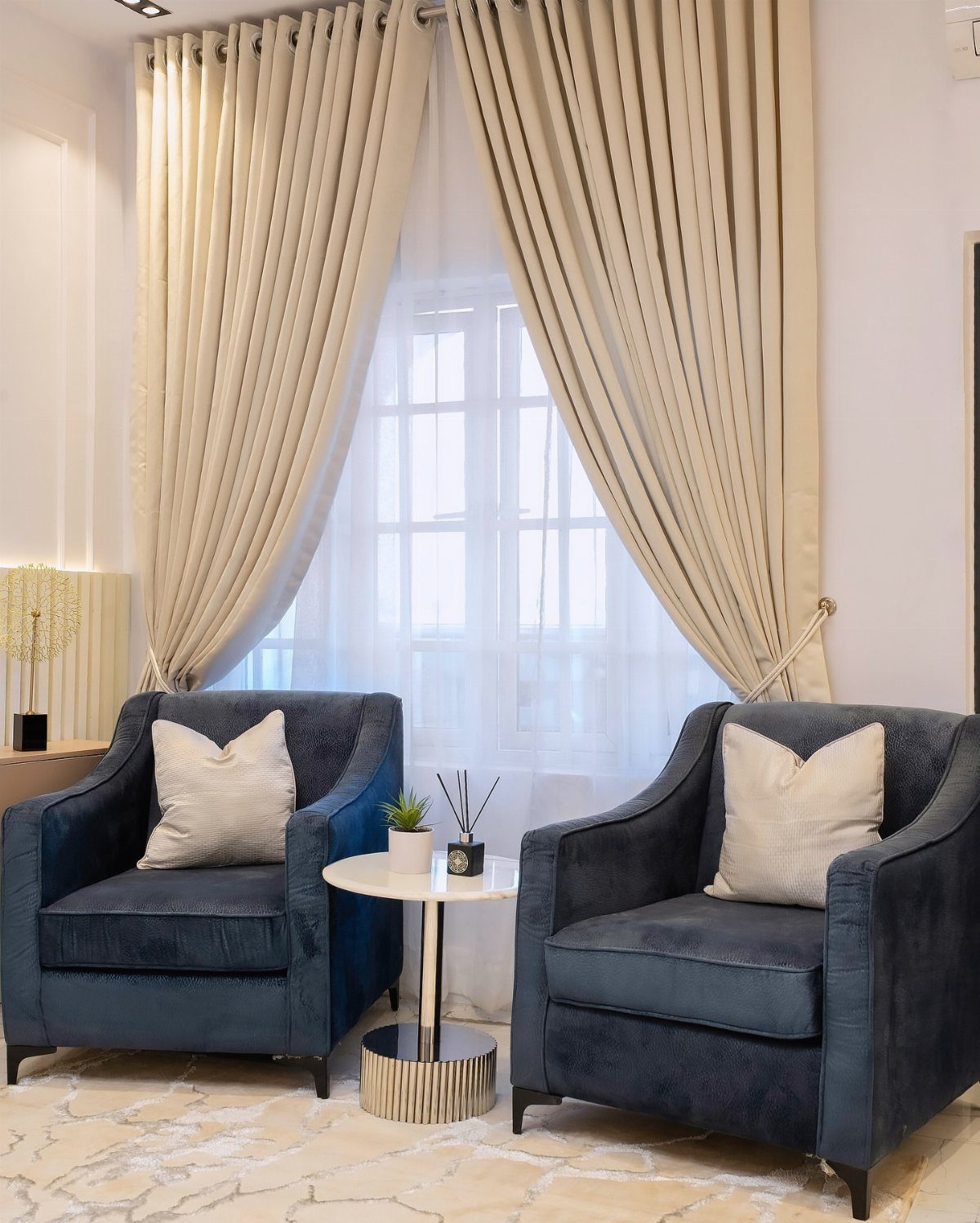11 Living Room Ideas with Accent Chairs 3 Two navy blue velvet accent chairs facing each other with a small marble table.
