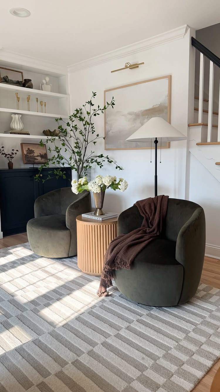 11 Living Room Ideas with Accent Chairs 11 Two olive green velvet accent chairs with a brown throw blanket and wooden side table.