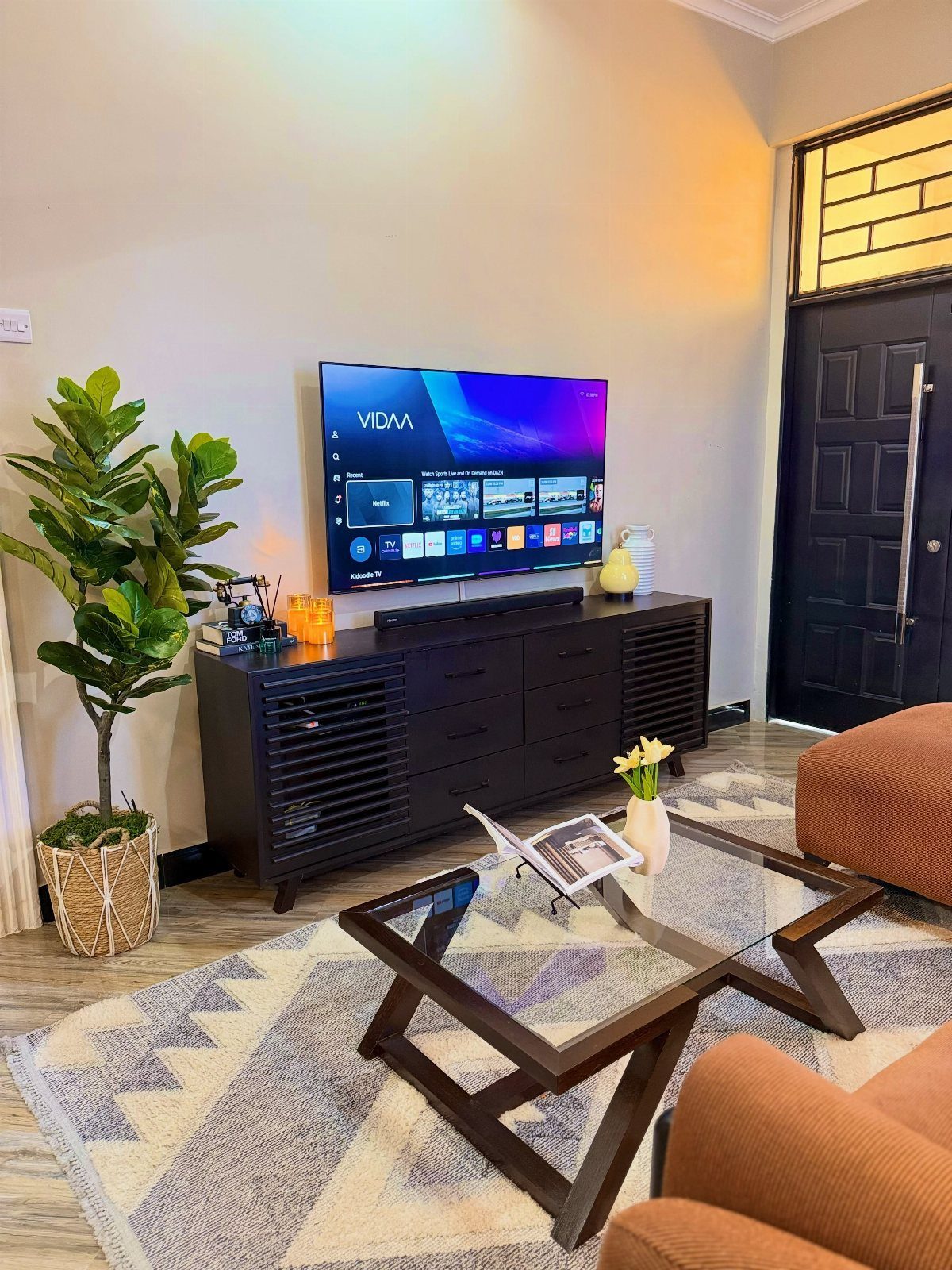 11 Living Room Ideas with Accent Chairs 10 Living room with brown accent chairs, glass coffee table, and a large television.