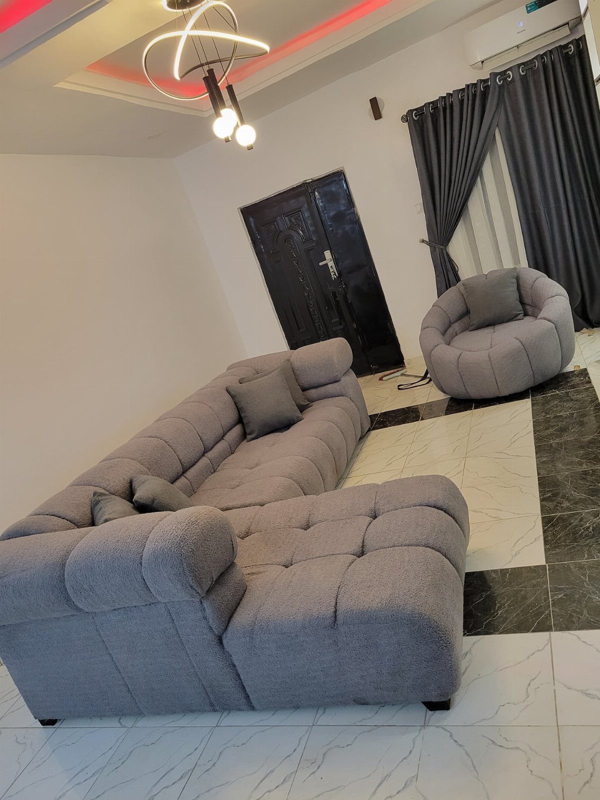 11 Living Room Ideas with Accent Chairs 7 Grey sectional sofa and a matching round accent chair in a modern living room.