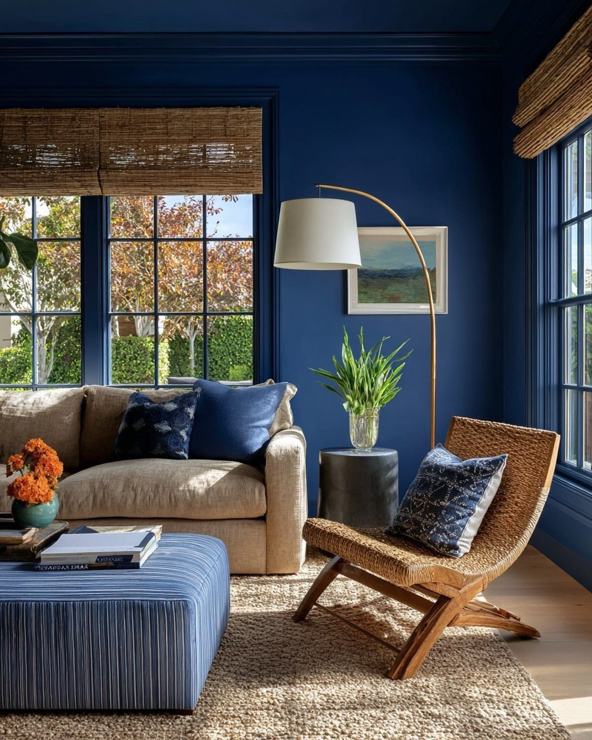 Navy blue living room with beige sofa, blue ottoman, and woven furniture.