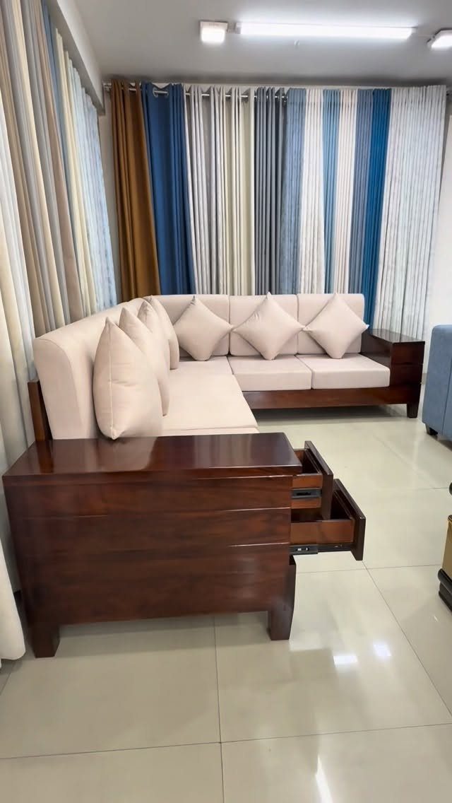 Dark brown wooden side table with an open drawer next to a beige sofa.