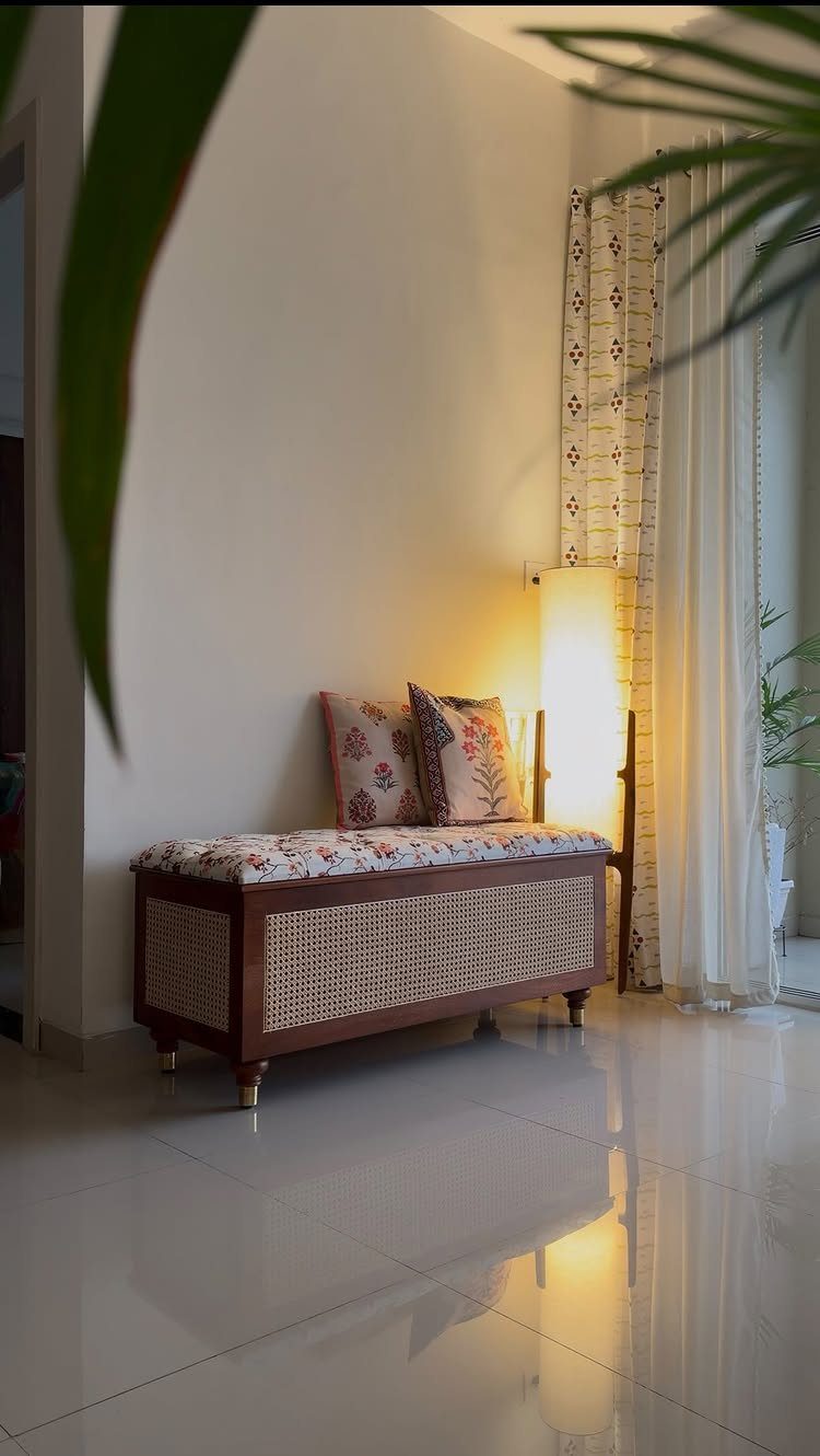 Wooden storage trunk with cane panels and floral cushion used as a bench.
